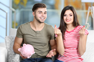 Young couple with piggy bank and money